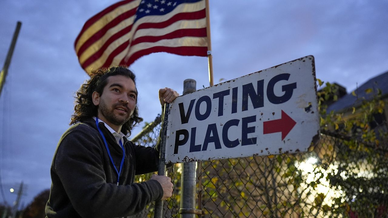 Election day worker Sean Vander Waal prepares to open a polling place,Tuesday, Nov. 5, 2024, in Dearborn, Mich. (AP Photo/Charlie Neibergall)