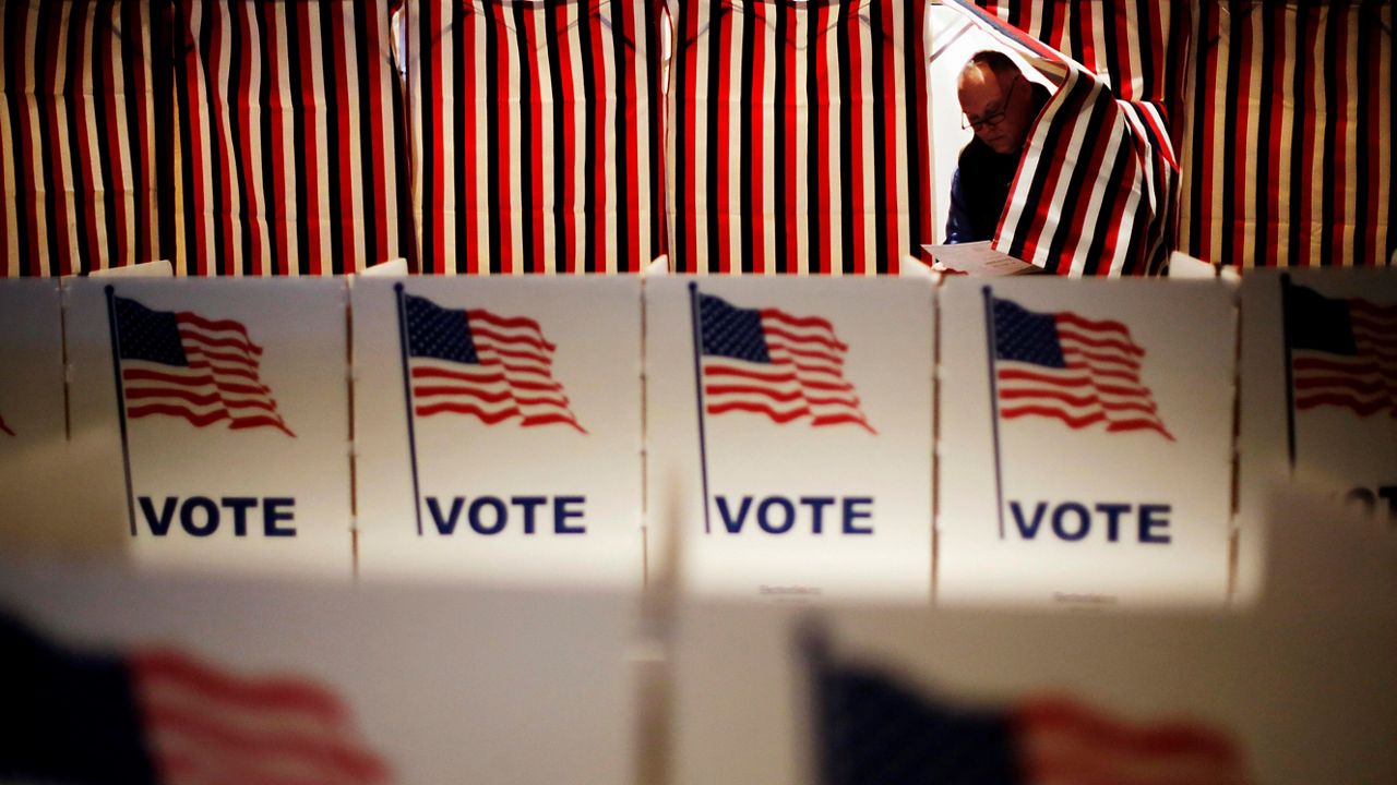 Jim Smith steps out of a voting booth after marking his ballot at a polling site for the New Hampshire primary, Tuesday, Feb. 9, 2016, in Nashua, N.H. (AP Photo/David Goldman)