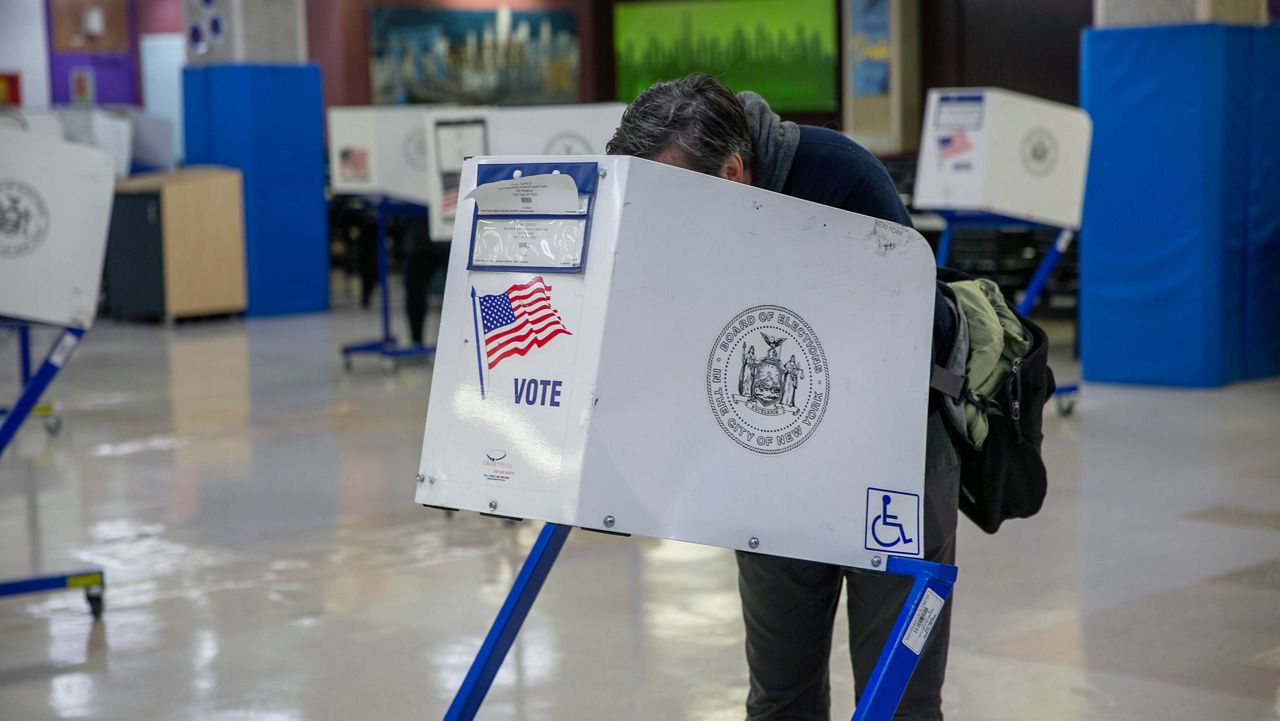 People in privacy booths vote in next week's midterm election at an early voting polling site at Frank McCourt High School on the Upper West Side of Manhattan in New York City on Tuesday, November 1, 2022. (AP Photo/Ted Shaffrey)