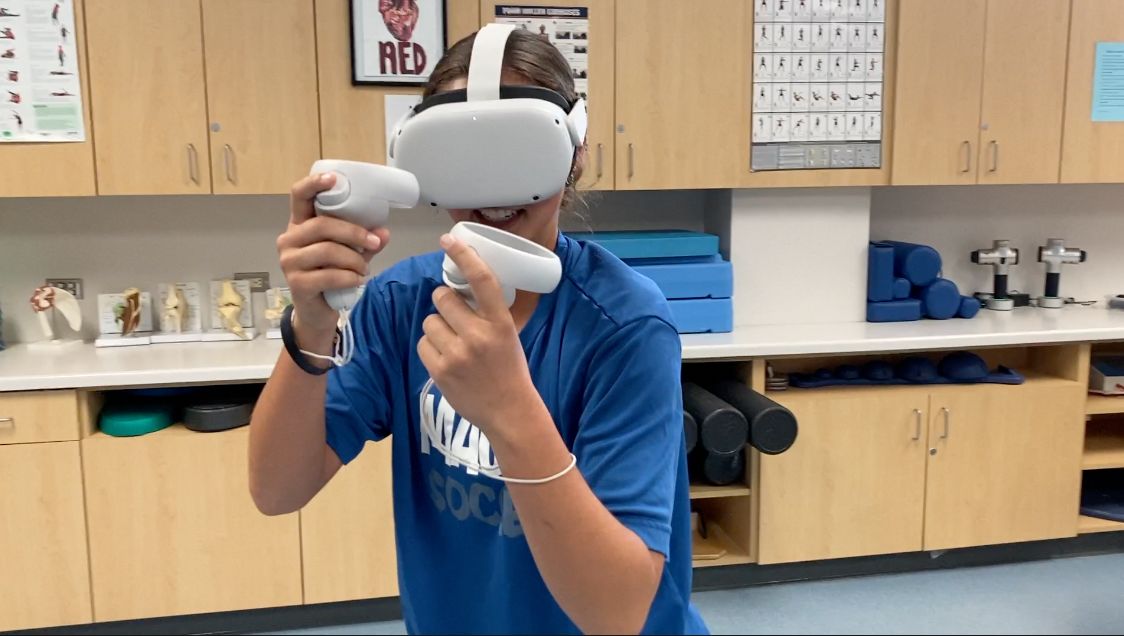 Bailey Fitzsimon rehabs using virtual reality headset. 