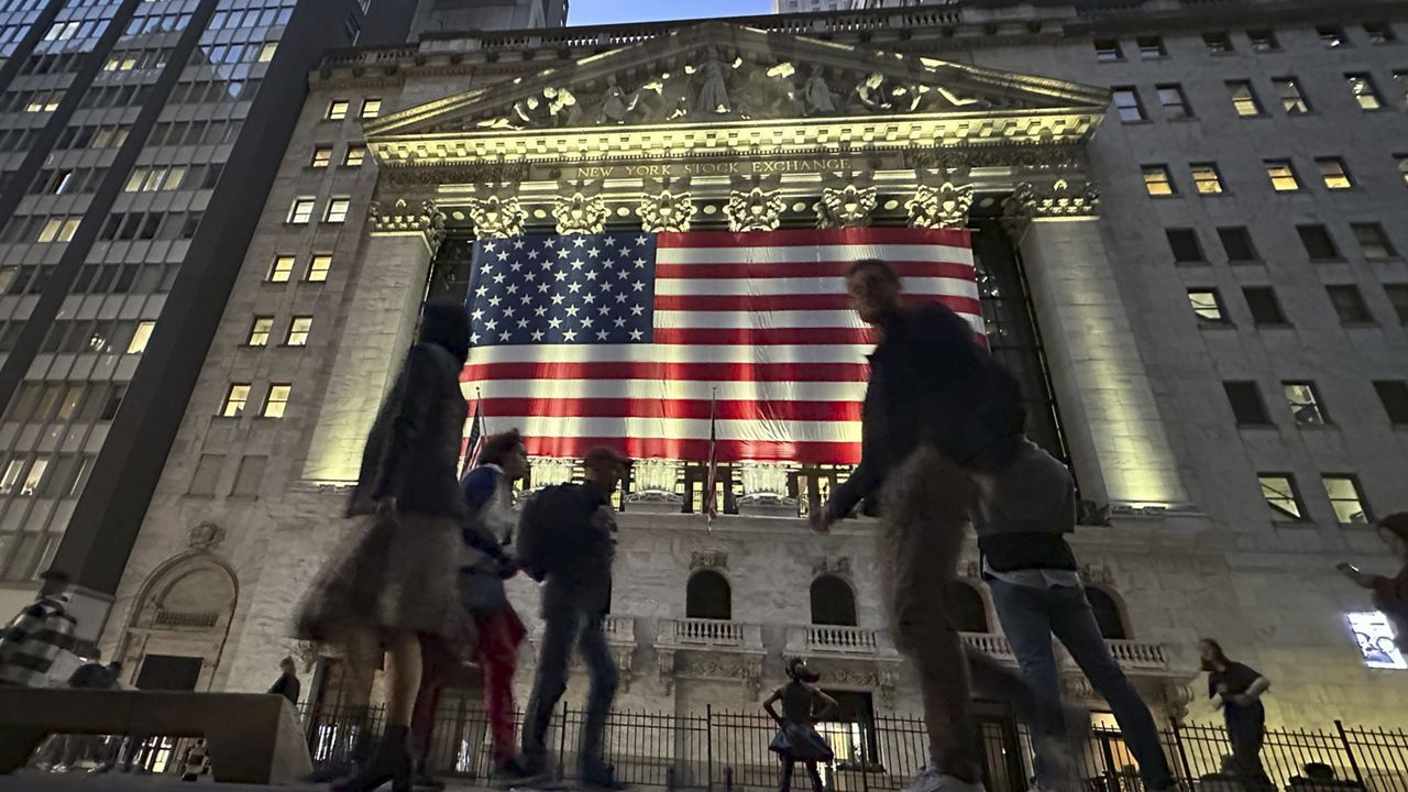 People pass the New York Stock Exchange in New York's Financial District on Tuesday, Nov. 5, 2024. (AP Photo/Peter Morgan)