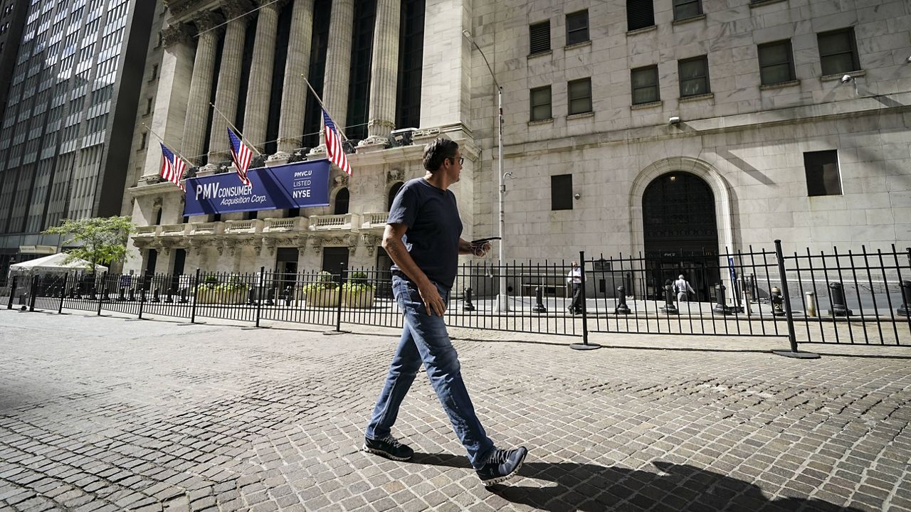 A pedestrian passes the New York Stock Exchange on Oct. 2, 2020. (AP Photo/John Minchillo)
