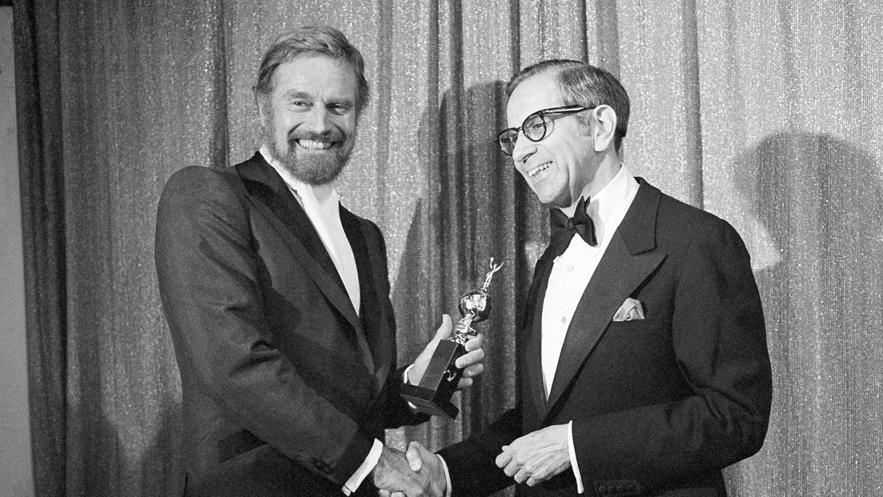 Walter Mirisch, right, and Charlton Heston celebrate at the 34th annual Golden Globe awards, presented by the Hollywood Foreign Press Association at the Beverly Hilton in Los Angeles, on Jan. 29, 1977. (AP Photo, File)