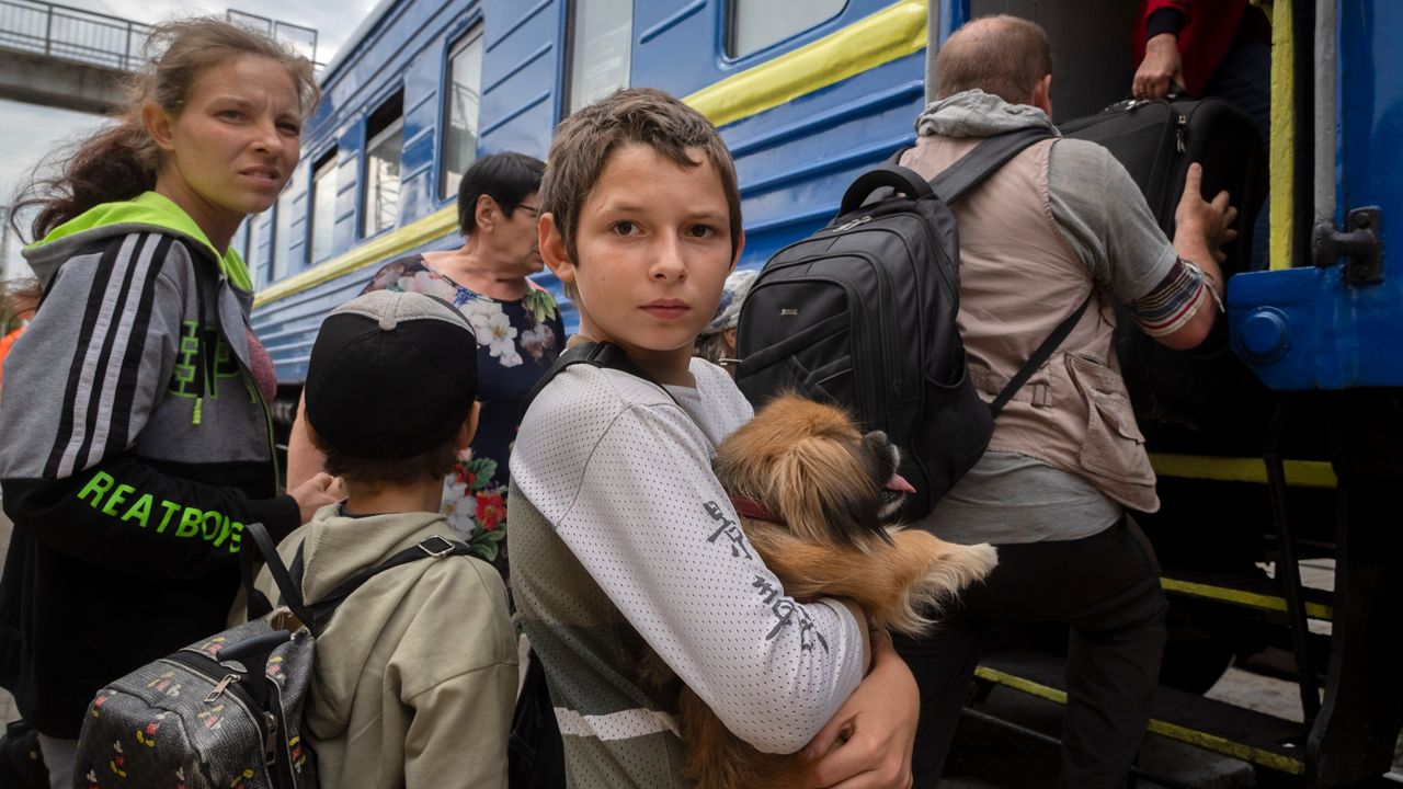 A boy holds his pet dog as his family is evacuated from Pokrovsk in eastern Ukraine on Saturday, June 25, 2022.