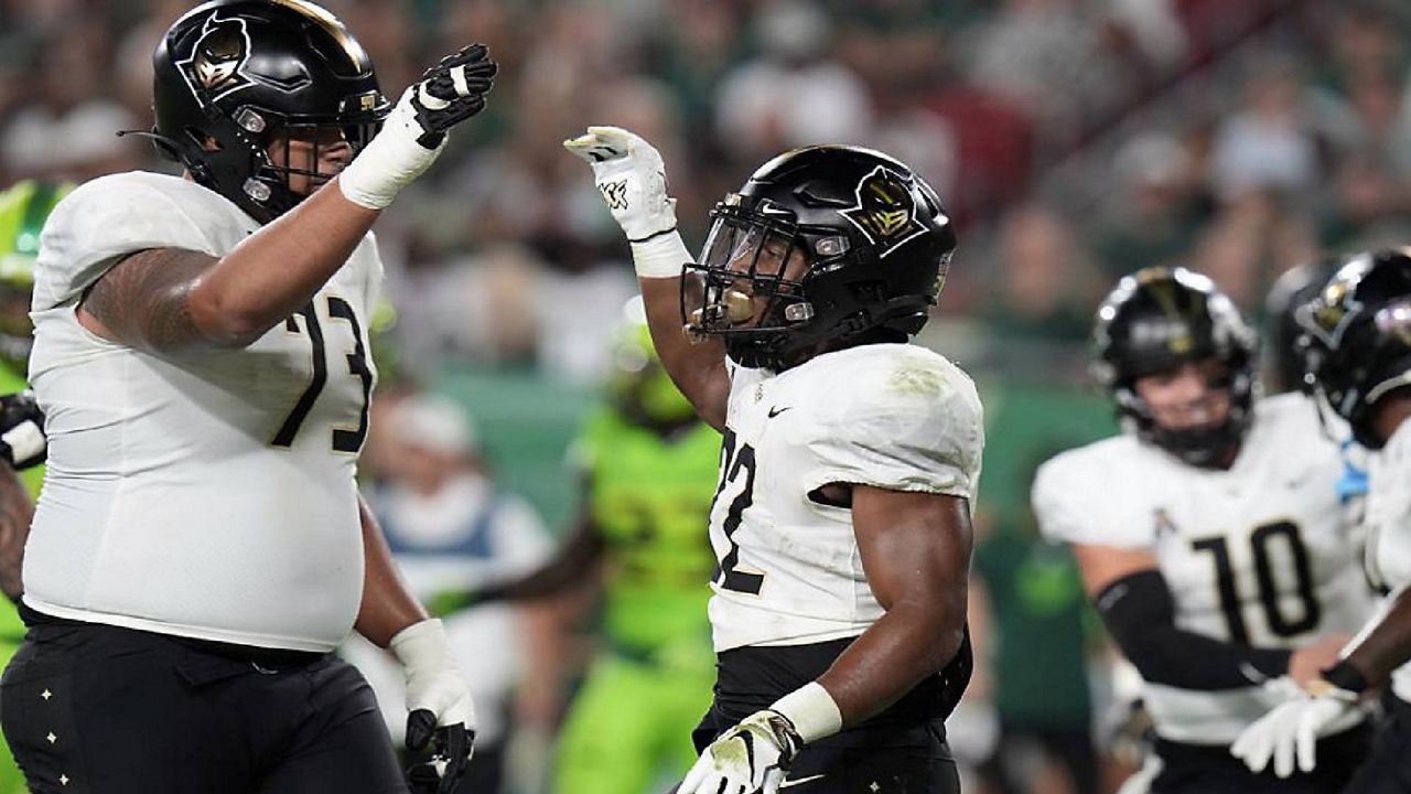 UCF running back RJ Harvey (22) celebrates with offensive lineman Samuel Jackson (73) after scoring on a 3-yard touchdown run against South Florida Saturday, Nov. 26, 2022, in Tampa, Fla. (AP Photo/Chris O'Meara)