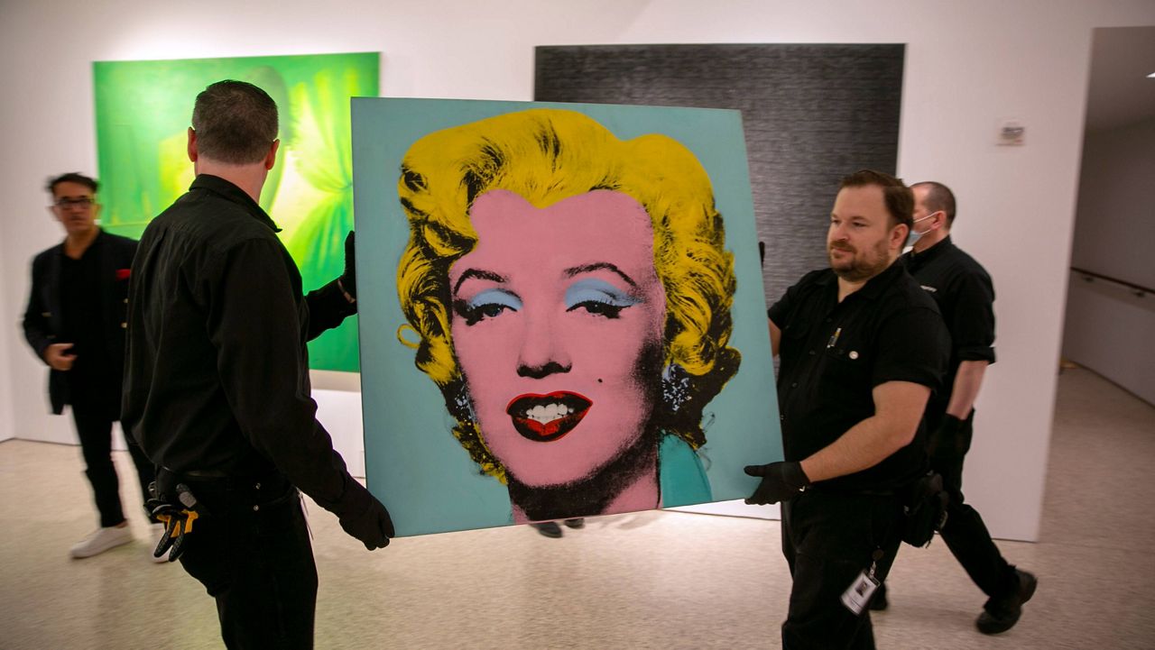 The 1964 painting Shot Sage Blue Marilyn by Andy Warhol is carried in Christie's showroom in New York City on Sunday. (AP Photo/Ted Shaffrey)