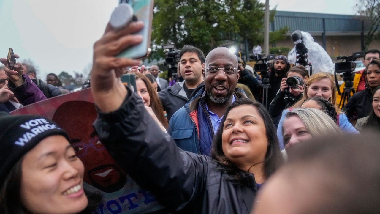 Democratic Sen. Raphael Warnock poses with supporters during an election day canvass launch on Tuesday, Dec. 6, 2022, in Norcross, Ga. (AP Photo/Brynn Anderson)