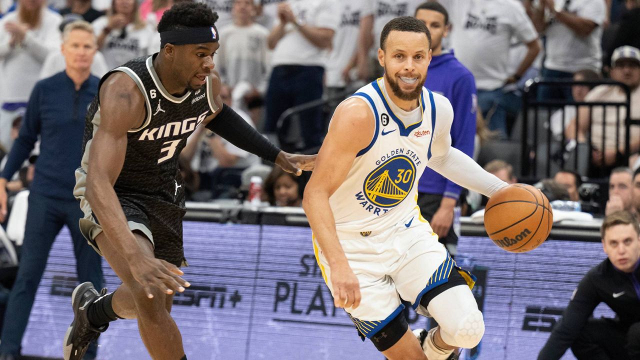 Golden State Warriors guard Stephen Curry (30) drives against Sacramento Kings guard Terence Davis (3) during the first half of Game 7 of an NBA basketball first-round playoff series, Sunday in Sacramento, Calif. (AP Photo/José Luis Villegas)