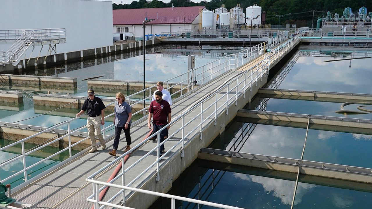 Jim Craig, with the Mississippi State Department of Health, left, leads Jackson Mayor Chokwe Antar Lumumba, right, Deanne Criswell, administrator of the Federal Emergency Management Agency (FEMA), center, and Mississippi Gov. Tate Reeves, rear, as they walk past sedimentation basins at the City of Jackson's O.B. Curtis Water Treatment Facility in Ridgeland, Miss., Friday, Sept. 2, 2022. 