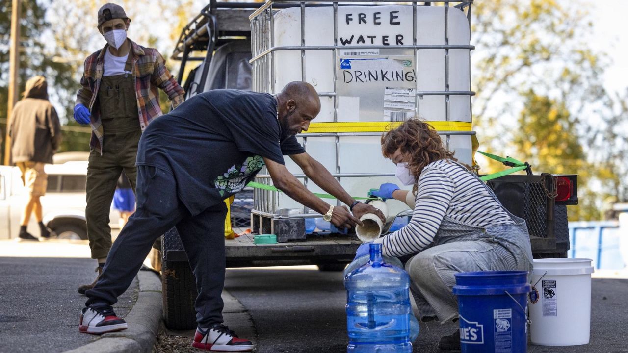 Volunteers with the grassroots group BeLoved Asheville fill bottles of drinking water for residents in low-income independent living facilities without running water, Oct. 8, 2024, in Asheville, N.C. (Travis Long/The News & Observer via AP, File)