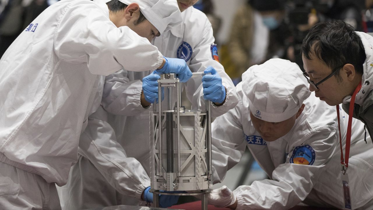 Technicians prepare to weigh a container carrying moon samples retrieved by China's Chang'e 5 lunar lander in Beijing on Dec. 17, 2020. (Jin Liwang/Xinhua via AP, File)