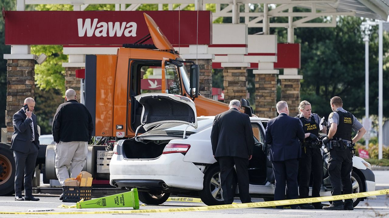 Crime investigators work the scene at a Wawa convenience store and gas station in Upper Macungie Township, Pa., on Wednesday. (AP Photo/Matt Rourke)