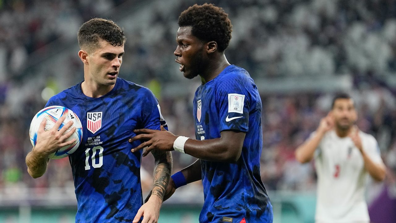 Christian Pulisic of the United States, left, and Yunus Musah of the United States speak before a free kick during the World Cup group B soccer match between Iran and the United States at the Al Thumama Stadium in Doha, Qatar, Tuesday, Nov. 29, 2022. (AP Photo/Ebrahim Noroozi)