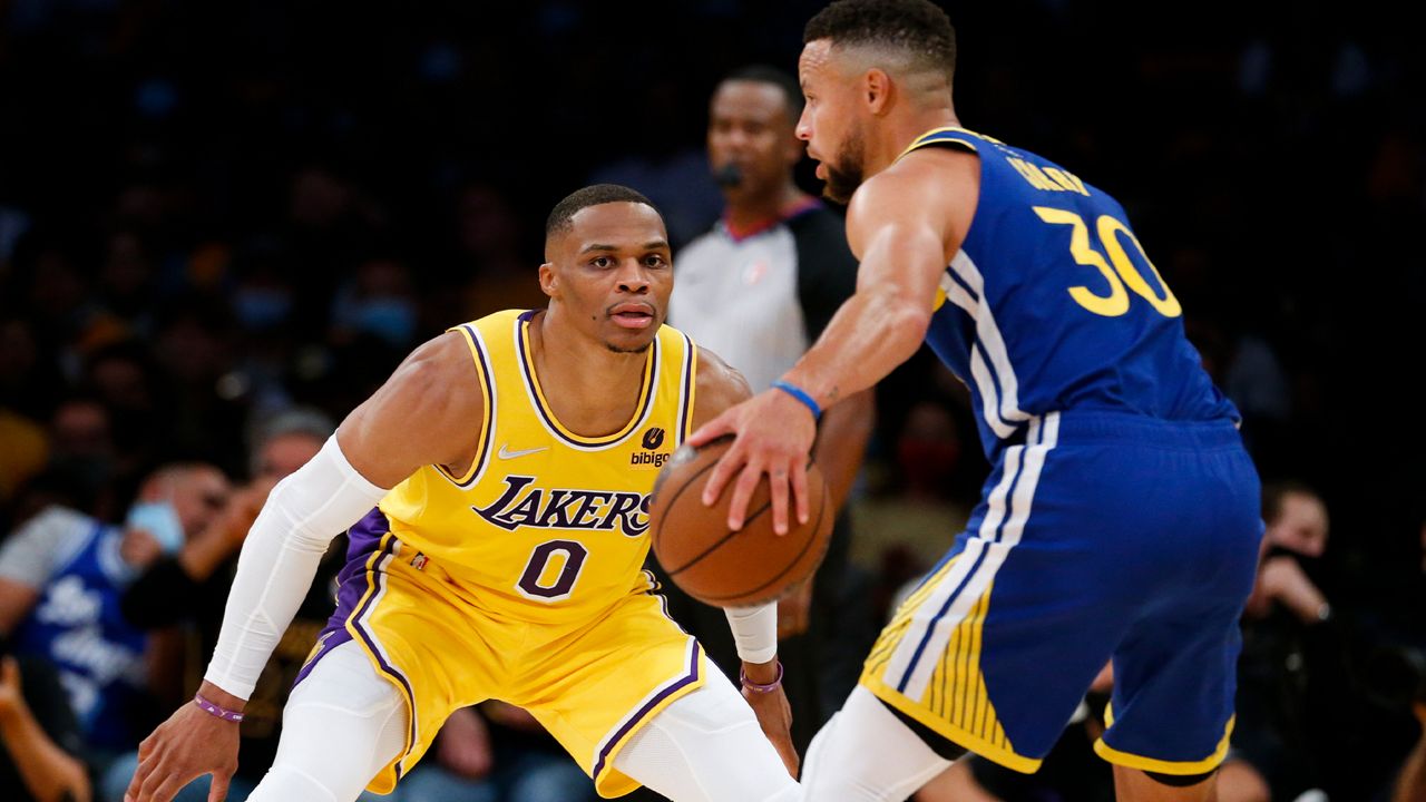 Los Angeles Lakers guard Russell Westbrook (0) defends against Golden State Warriors guard Stephen Curry (30) during the first half of an NBA basketball game in Los Angeles, Tuesday, Oct. 19, 2021. (AP Photo/Ringo H.W. Chiu)
