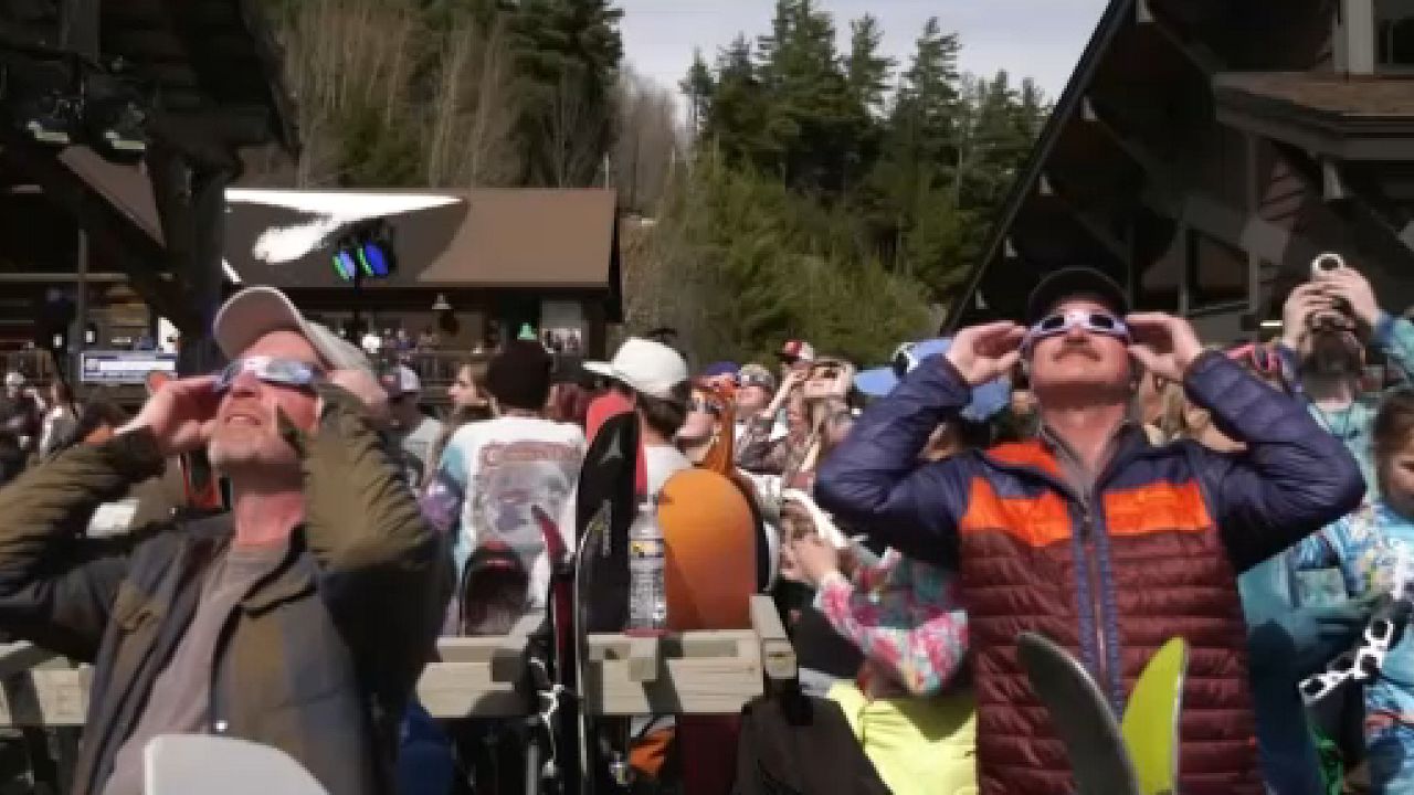 Visitors to Whiteface Mountain observe the solar eclipse on Monday.