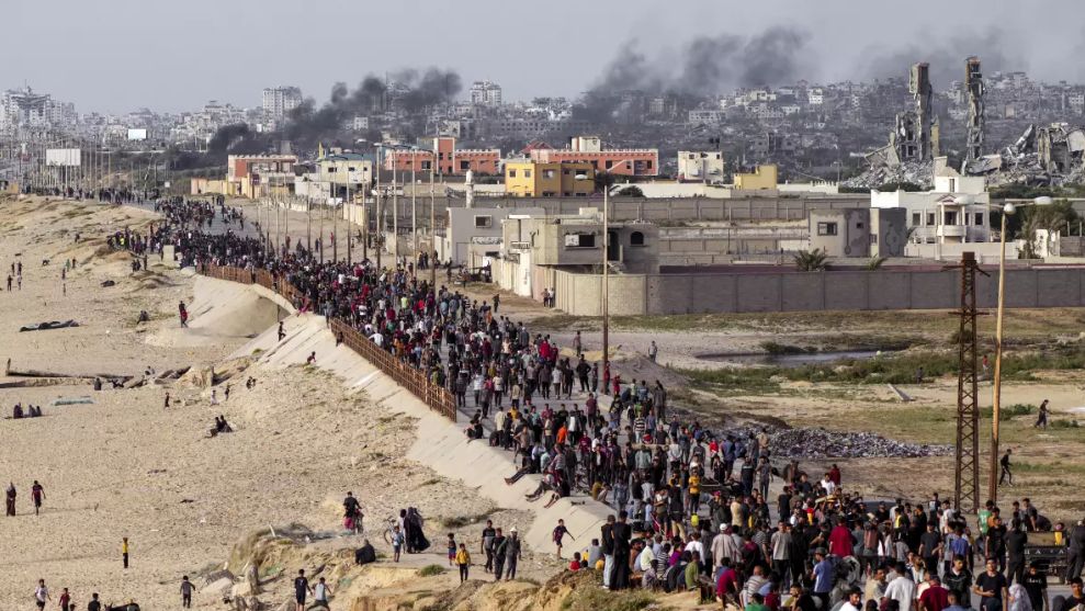 FILE - Palestinians wait for aid trucks to arrive in the central Gaza Strip on May 19. (Associated Press/Abdel Kareem Hana)