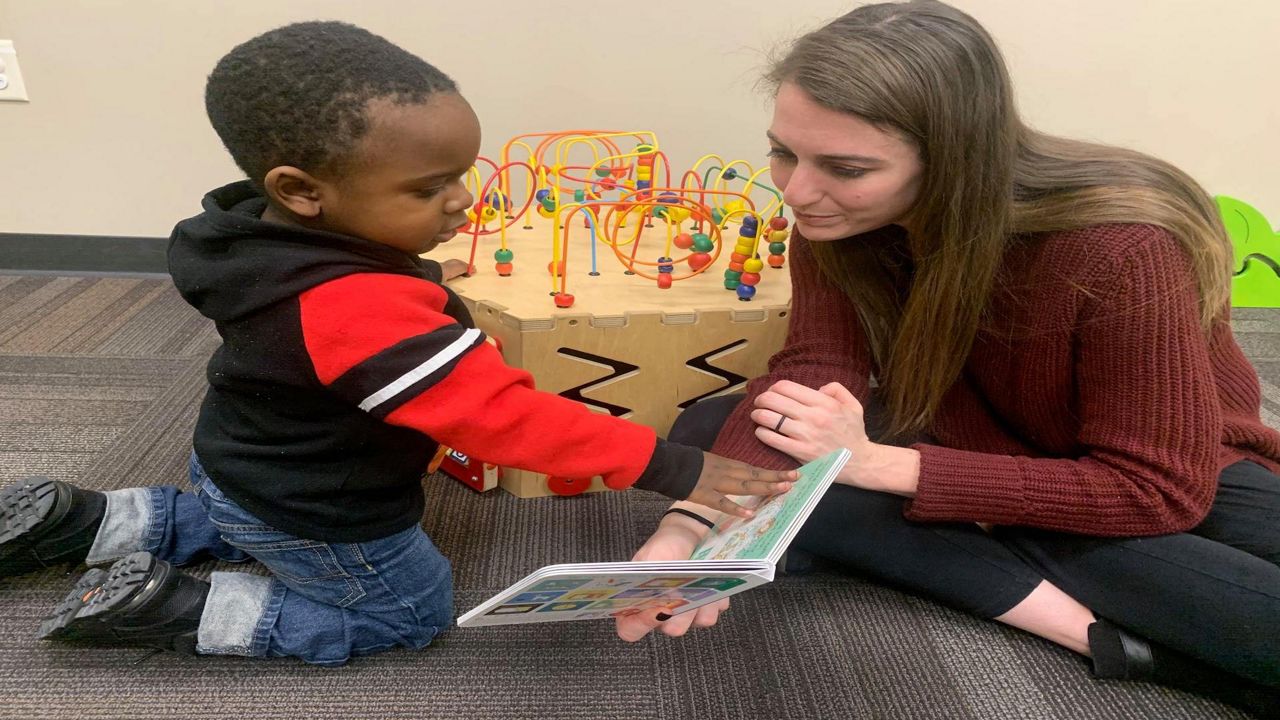 Kait Laux reads to a child at a WIC Clinic