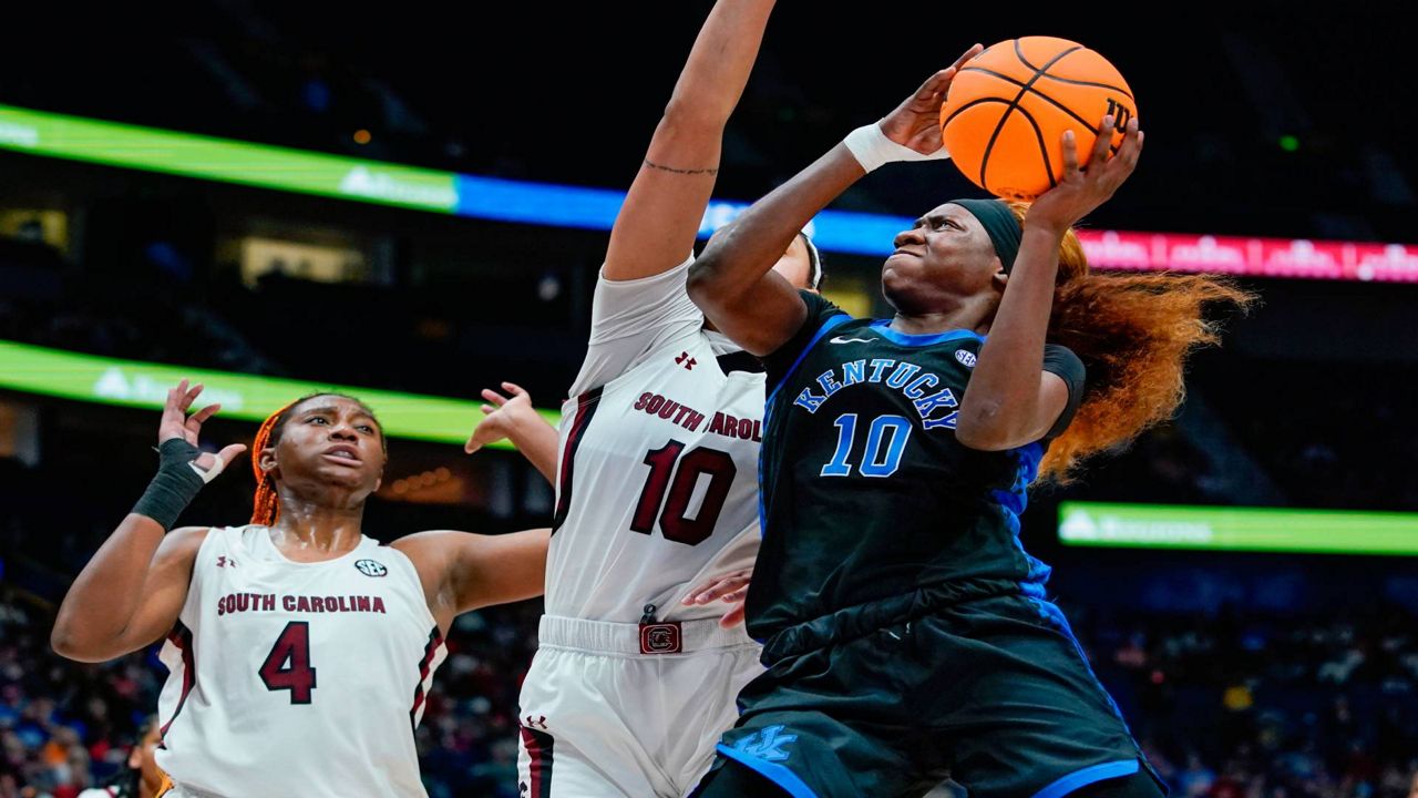 Kentucky's Rhyne Howard, right, drives against South Carolina's Kamilla Cardoso, center, and Aliyah Boston (4) in the first half of the NCAA women's college basketball Southeastern Conference tournament championship game Sunday, March 6, 2022, in Nashville, Tenn. (AP Photo/Mark Humphrey)