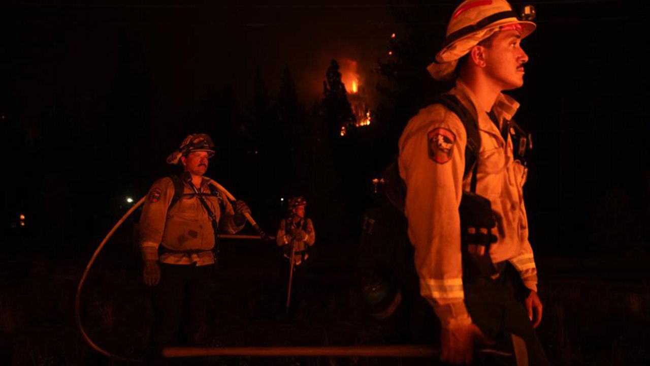 In this Wednesday, Sept. 1, 2021, file photo, firefighters are lit by a backfire set to prevent the Caldor Fire from spreading near South Lake Tahoe, Calif. (AP Photo/Jae C. Hong, File)