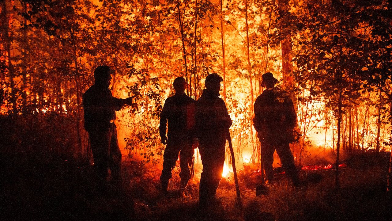 Firefighters work at the scene of forest fire near Kyuyorelyakh village in the Gorny Ulus area of Russia on Aug. 5, 2021. (AP Photo/Ivan Nikiforov, File)