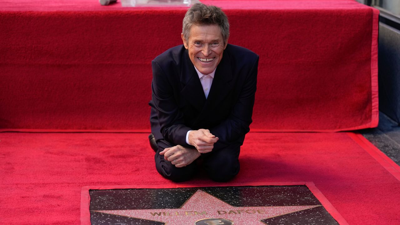 Willem Dafoe touches his new star at a ceremony honoring him with the star on the Hollywood Walk of Fame