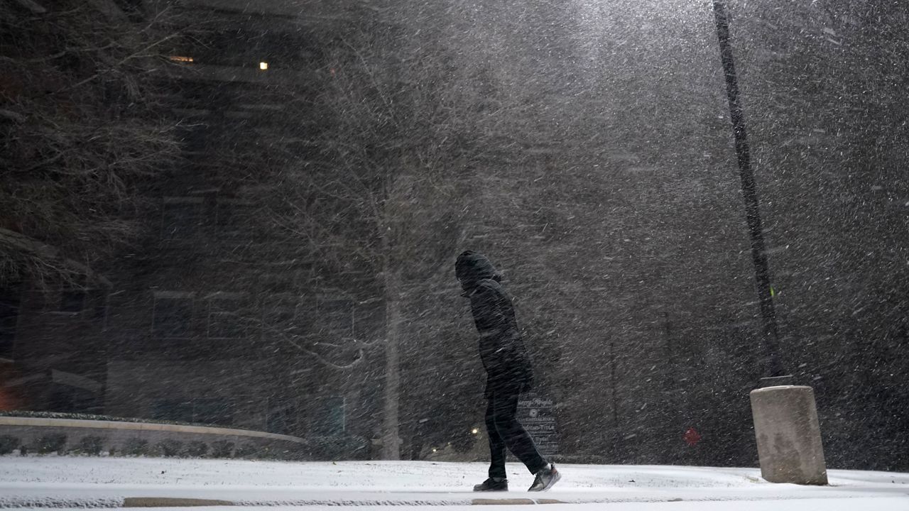 In this Feb. 14, 2021, file photo, woman walks through falling snow in San Antonio. (AP Photo/Eric Gay, File)