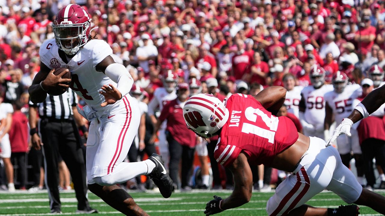 Alabama's Jalen Milroe (4) runs for a touchdown past Wisconsin's Max Lofy 