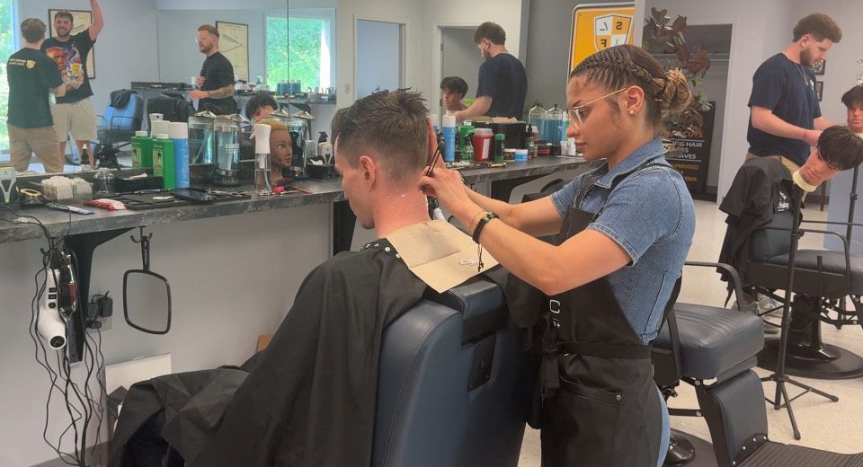 Female barber student giving a haircut