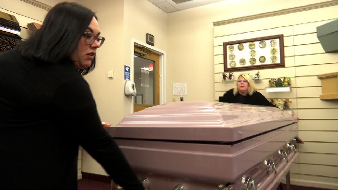 Vancil-Coleman and Pattee move a casket.