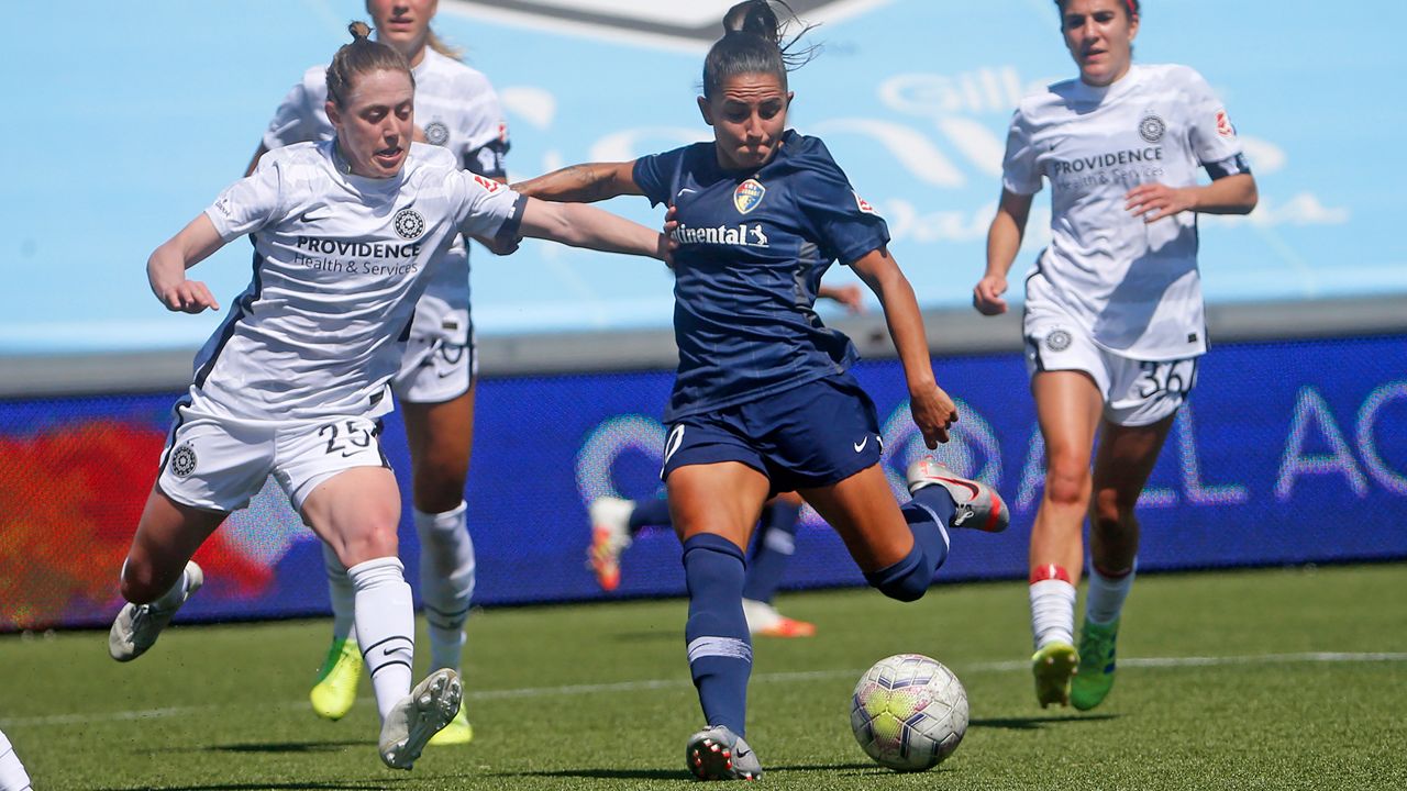 North Carolina Courage's Debinha, center, kicks the ball as Portland Thorns' Meghan Klingenberg (25) defends during the first half of an NWSL Challenge Cup soccer match at Zions Bank Stadium Friday, July 17, 2020, in Herriman, Utah. (AP Photo/Rick Bowmer)