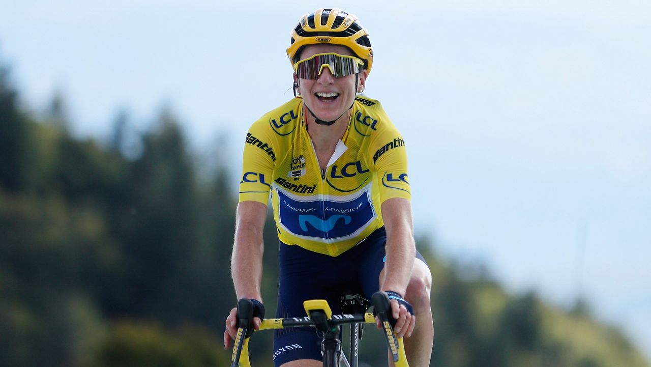 Netherland's Annemiek Van Vleuten, wearing the overall leader's yellow jersey, smiles as she crosses the finish line after winning the 8th stage of the Tour de France women's cycling race from Lure to La Super Planche des Belles Filles, eastern France, Sunday, July 31, 2022. (AP Photo/Jean-Francois Badias)