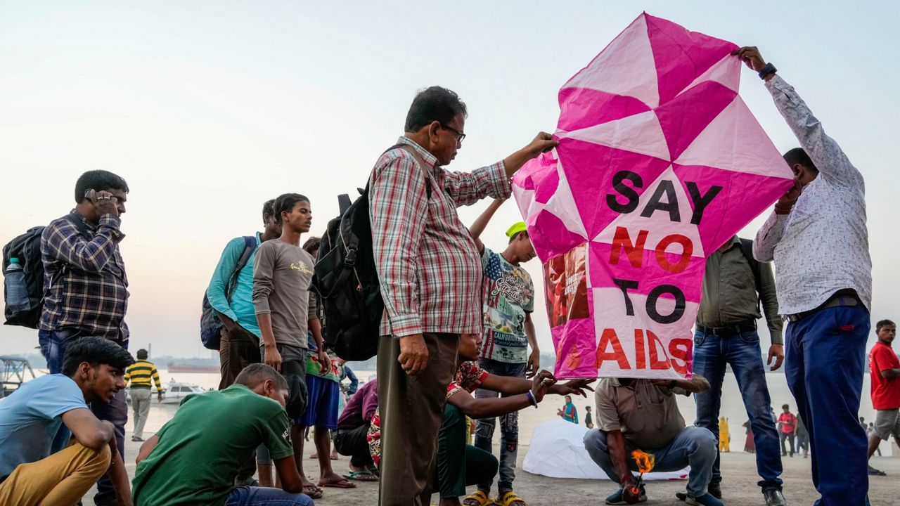 Activists prepare Wednesday to release a sky lantern with a message on the banks of the Hooghly River in Kolkata, India, ahead of World AIDS Day. (AP Photo/Bikas Das)