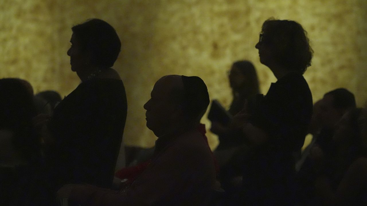 Worshipers stand to say the names of loved ones in need of prayers during a Shabbat service, Friday, Sept. 27, 2024, at Temple Beth Sholom in Miami Beach, Fla. (AP Photo/Wilfredo Lee)