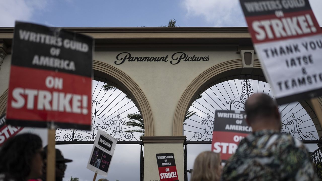 Demonstrators walk with signs during a rally outside the Paramount Pictures Studio in Los Angeles, Thursday, Sept. 21, 2023. A tentative deal was reached, Sunday, Sept. 24, 2023, to end Hollywood’s writers strike after nearly five months. (AP Photo/Jae C. Hong, File)