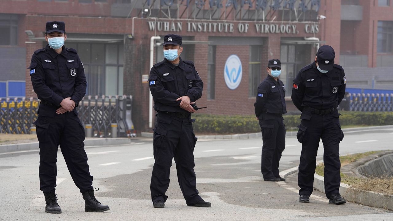 Security personnel gather near the entrance of the Wuhan Institute of Virology during a visit by the World Health Organization team on Wednesday. (AP Photo/Ng Han Guan)