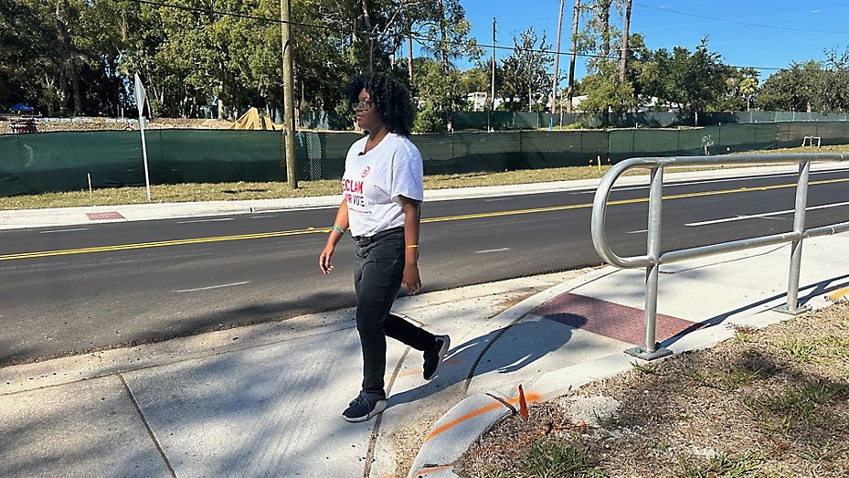 Jade Prince walks along Wymore Road, where a project funded by a penny sales tax is wrapping up. (Spectrum News/Jerry Hume)