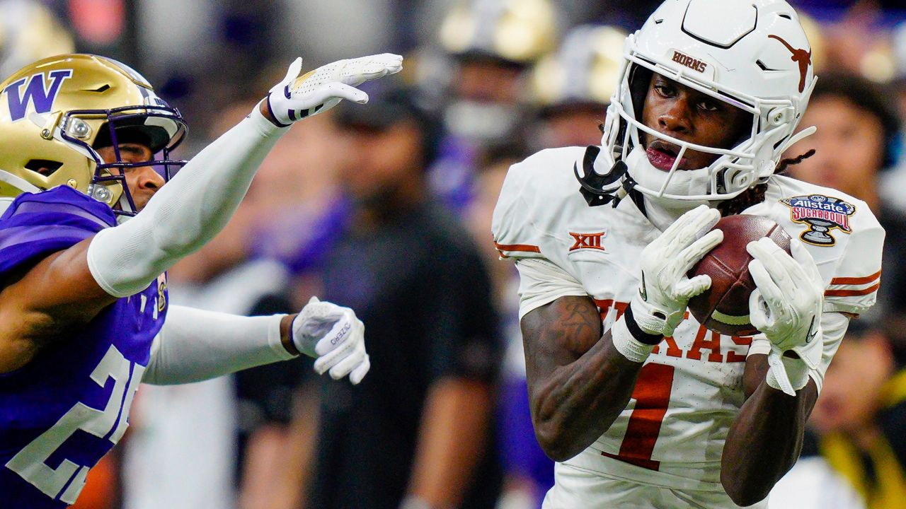 Texas wide receiver Xavier Worthy (1) makes a catch while covered by Washington cornerback Elijah Jackson, left, during the Sugar Bowl CFP NCAA semifinal college football game Jan. 1, 2024, in New Orleans. (AP Photo/Jacob Kupferman, File)