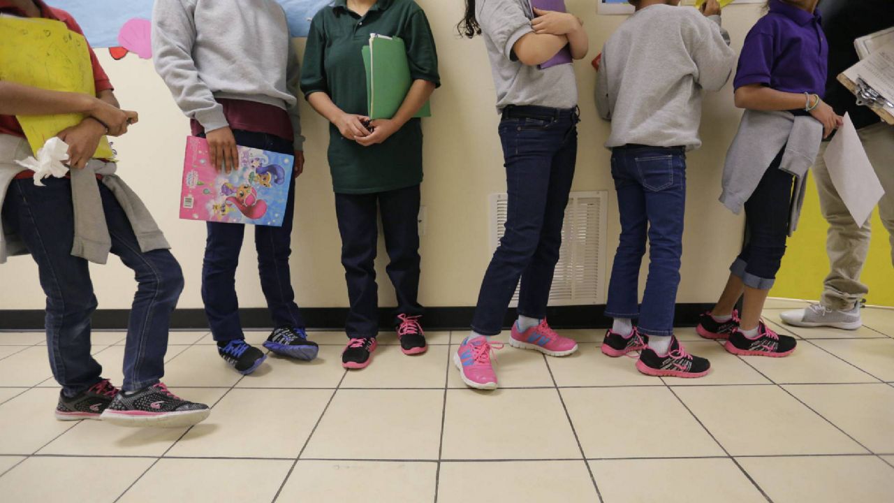 FILE - In this Aug. 29, 2019, file photo, migrant teens line up for a class at a "tender-age" facility for babies, children and teens, in Texas' Rio Grande Valley, in San Benito, Texas. (AP Photo/Eric Gay File)