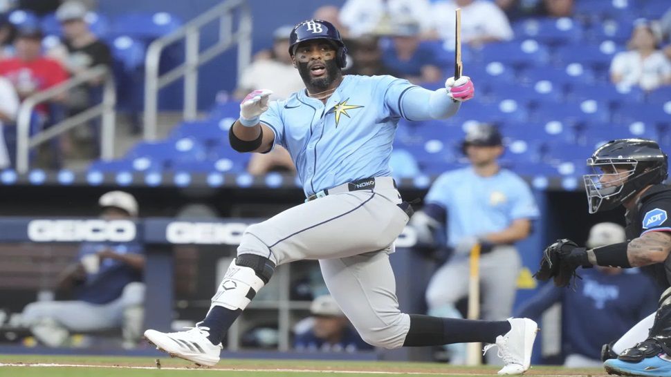 Tampa Bay Rays' Yandy Díaz (2) holds on to what remains of his broken bat during the first inning of a baseball game against the Miami Marlins, Friday, May 16, 2025, in Miami. (AP Photo/Marta Lavandier)