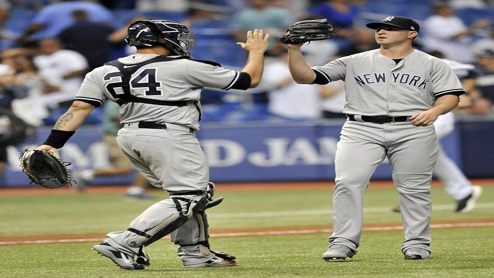 New York Yankees catcher Gary Sanchez (24) celebrates a 4-1 win over the Tampa Bay Rays with reliever Zach Britton at the end of a baseball game Monday, Sept. 24, 2018, in St. Petersburg, Fla. (AP Photo/Steve Nesius)