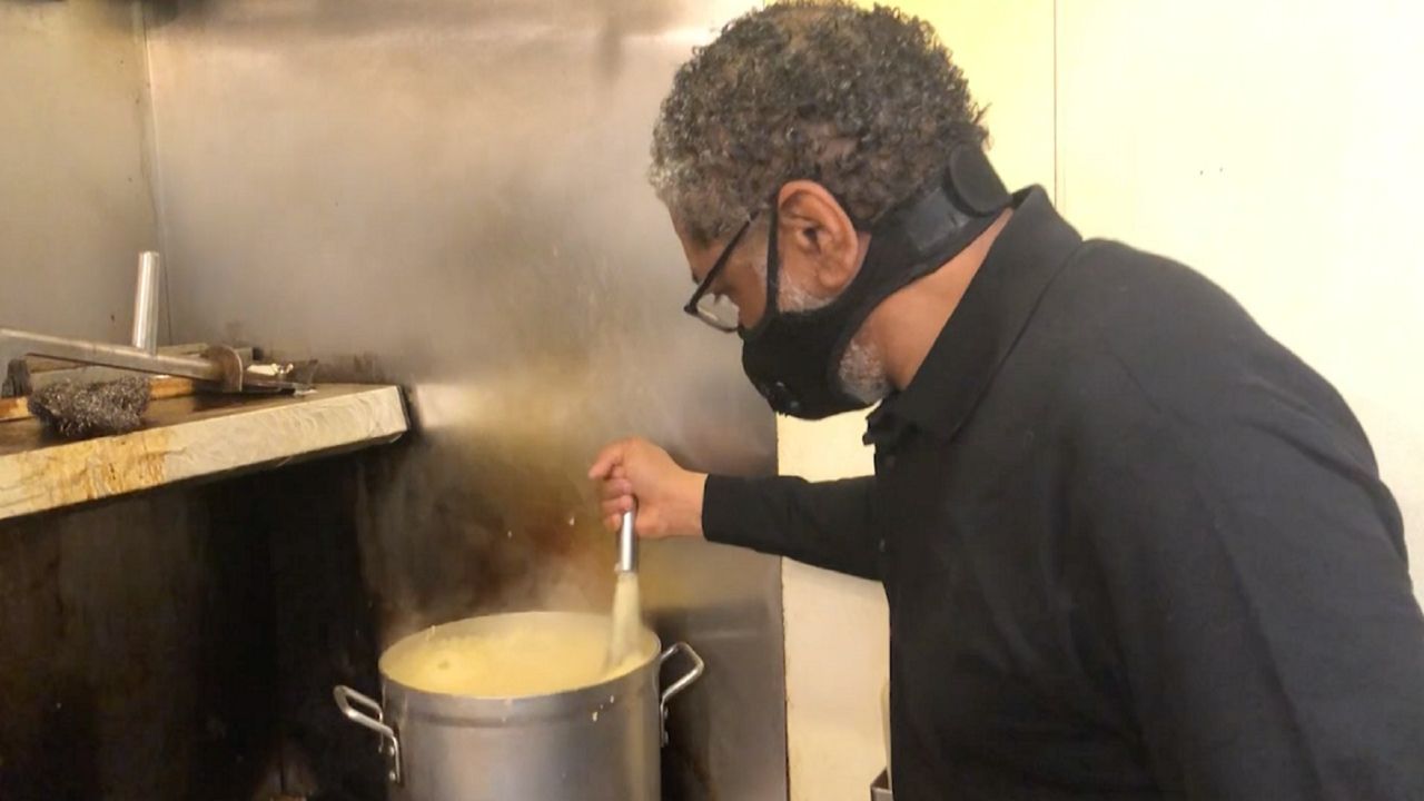Johnny Hutton stirs some grits in the kitchen of Zanzibar Soul Fusion in downtown Cleveland's Gateway District