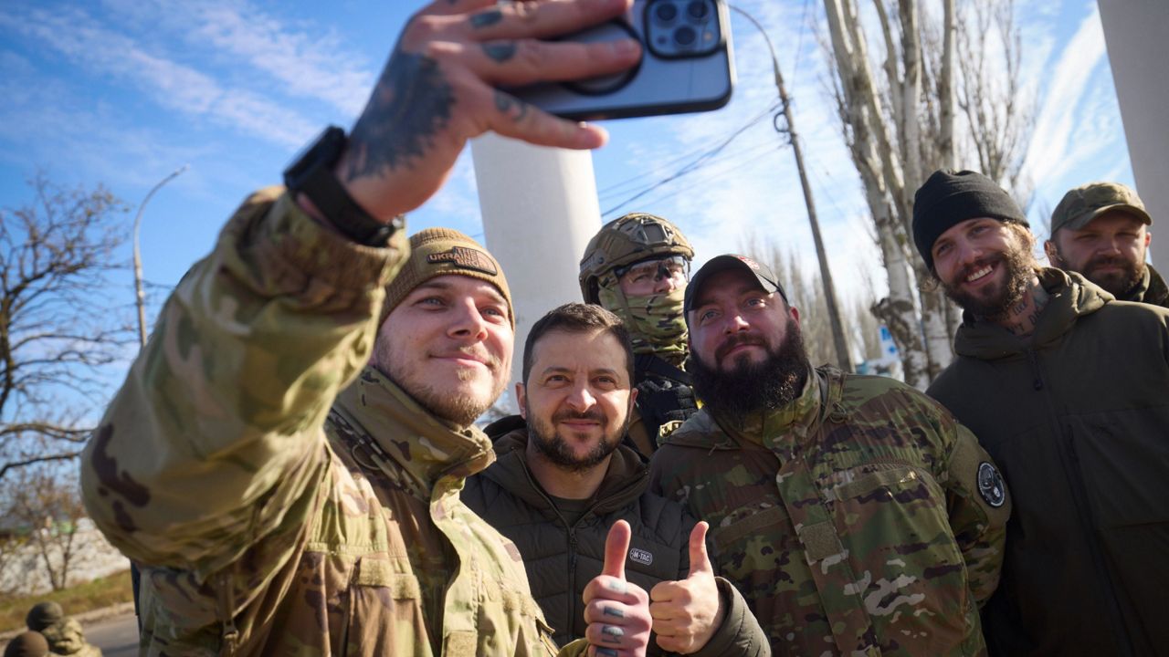 Ukrainian soldiers take a selfie with President Volodymyr Zelenskyy, center, during his visit Monday to Kherson, Ukraine. (Ukrainian Presidential Press Office via AP)