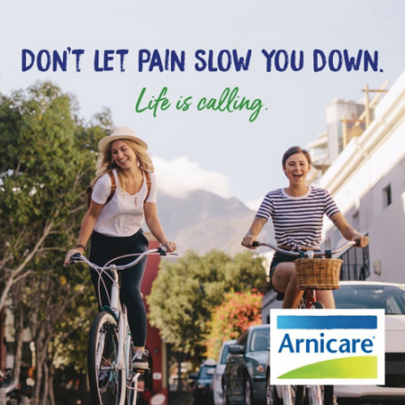 Two cyclists with Arnicare logo and text: Don't Let Pain Slow You Down