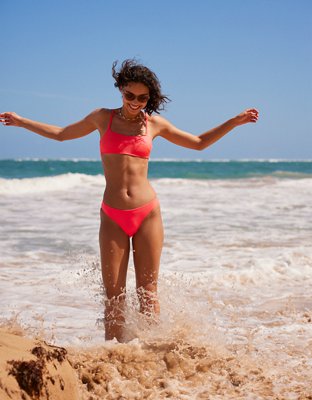 Girl torso, glistening wet, in dark red bikini bottom, laying on side and  on straw mat with blue sky and puffy clouds. - SuperStock