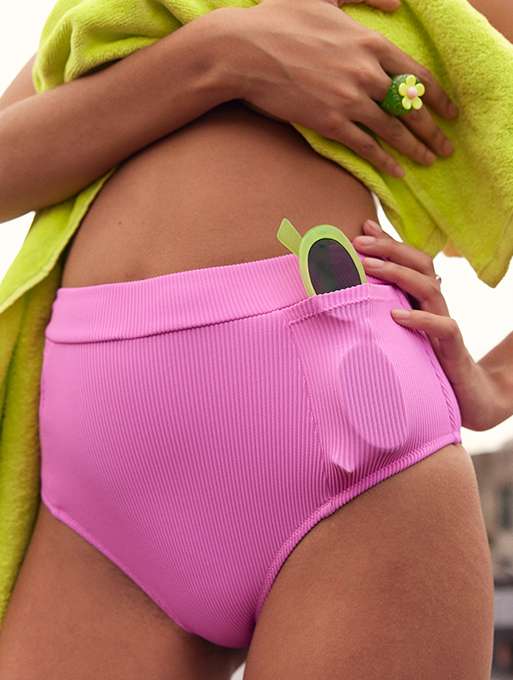 close up of woman's bikini bottoms with pocket holding her sunglasses