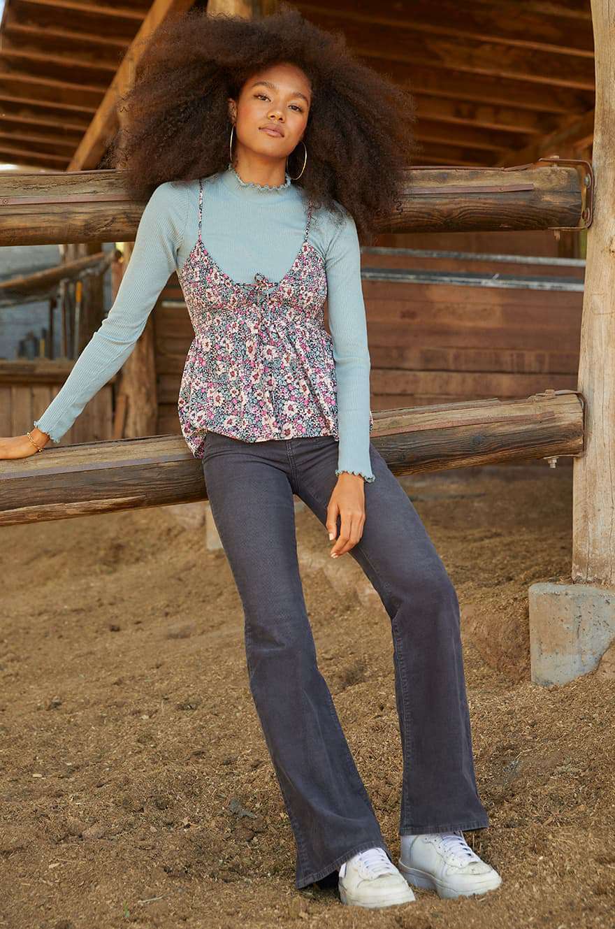 model in barn wearing AE jeans with a tank top over a turtleneck