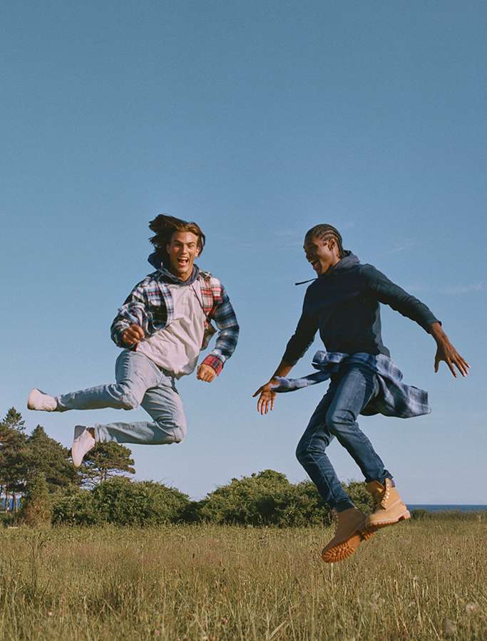 two models jumping in field