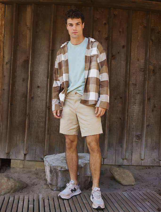 model wearing khaki shorts and flannel