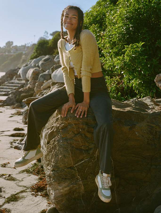model sitting on rock