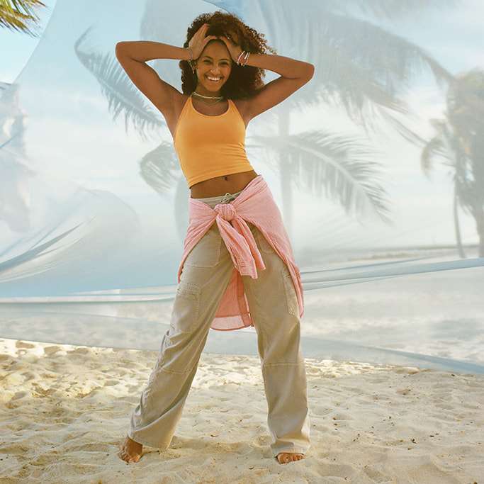 model on beach wearing AE Dreamy Drape pants